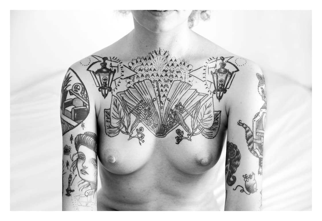 Pecho y hombros tatuados de frente, con un gran diseño simétrico ocupando el esternón