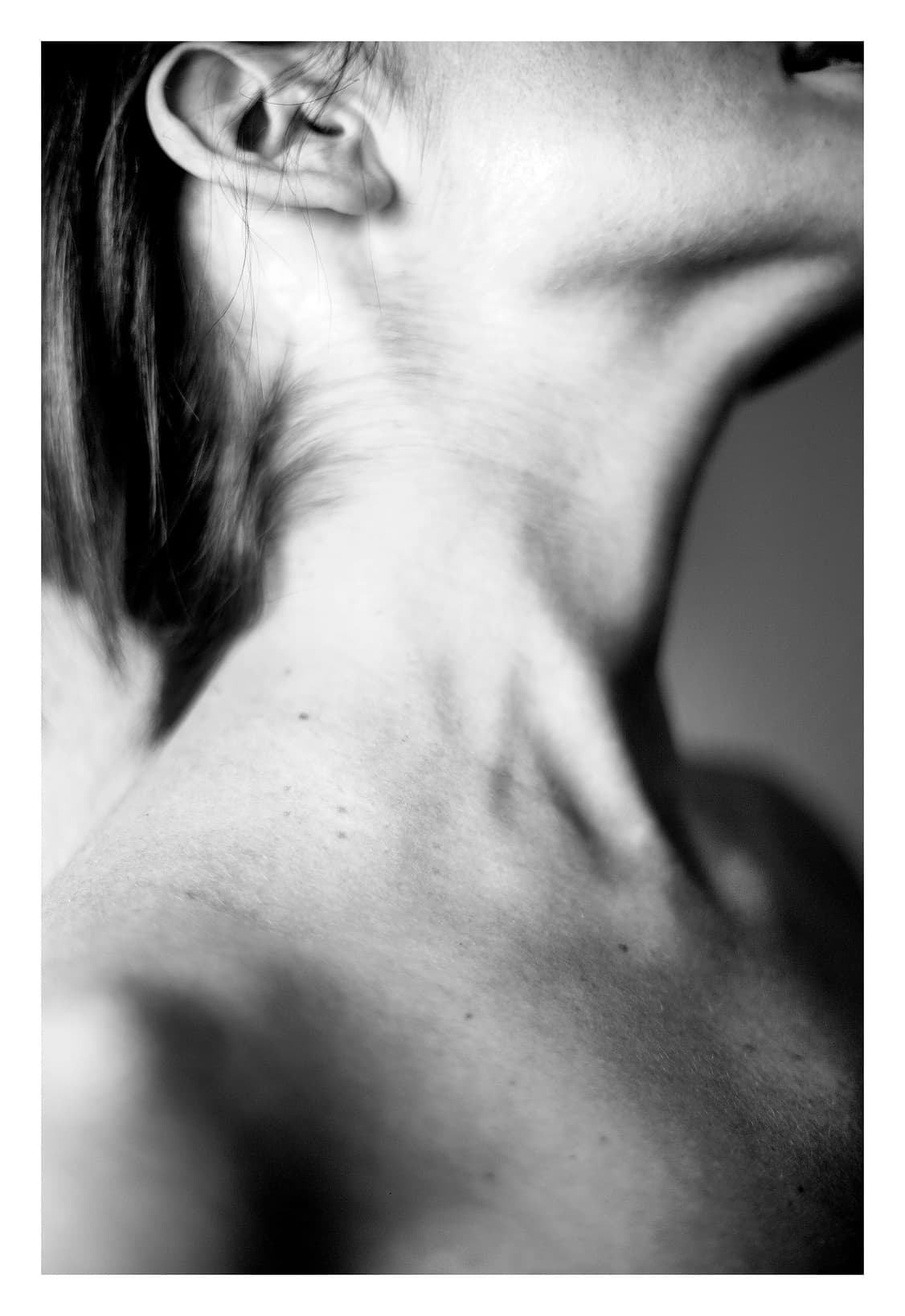 Cuello y hombro desnudos vistos desde muy cerca y desde abajo, con la piel tensa